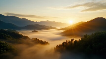 Fototapeta premium A breathtaking sunrise over foggy mountains, showcasing the serene beauty of nature in all its glory.