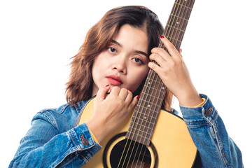 Beautiful Asian girl in jeans shirt hugging acoustic guitar isolated on white background and looking at camera, studio shot