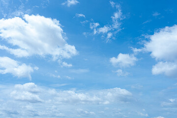 Fluffy white clouds drift across a vibrant blue sky, creating a breathtaking natural masterpiece