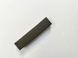 black eraser made of synthetic rubber or natural rubber on a white background
