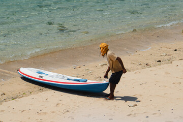 A man carrying canoe to the coast, Bali, Indonesia