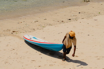 A man carrying canoe to the coast, Bali, Indonesia
