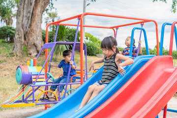 Little boys and girls play on the playground equipment at school, kindergarten, or the playground. Healthy summer activities. Outdoor play. Happy children. Relaxation. Childhood concept.