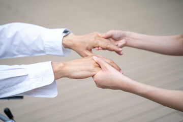 シニア男性の手を握る女性の手