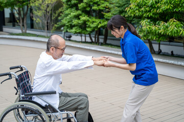 車いすから立ち上がる介助をする介護施設スタッフ