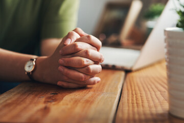 Woman, hands and praying on desk for support, Jesus christ and christian praise for salvation in home. Female person, spiritual healing and thank you to God, practice religion and grace for peace