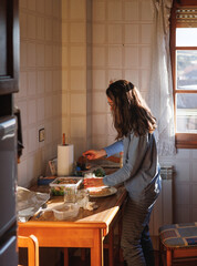 Young woman in pajamas preparing tupper food at home before going out.