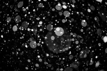  Bokeh lights on black background, shot of flying snowflakes in the air