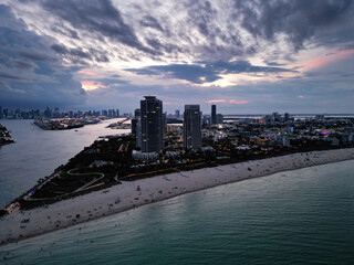 Fototapeta premium Miami Beach, South Beach at night. Miami seaside at dusk. Aerial view of evening Miami Beach and cityscape. Coastline of Miami Beach night shot from the air drone.