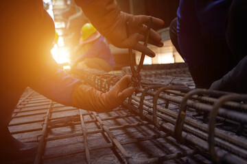 A group of builders is busy constructing a metal structure