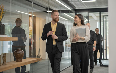 Obraz premium Strategic Dialogue: Young Professionals Engaged in Office Discussion 