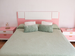 Double bed with pillows in interior of the modern bedroom in loft flat in light color style of expensive apartments
