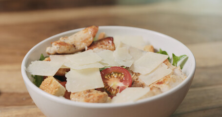 parmesan flakes falling on caesar salad