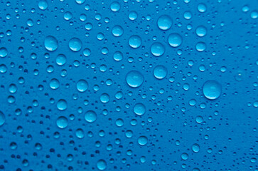 Focus on water droplets on blue cover background suitable for wallpaper. Water droplets and wallpaper concept