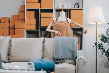 Asian SME business women use laptop computer checking customer order online shipping boxes at home....