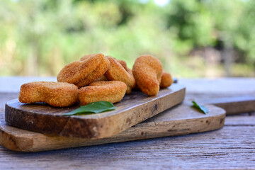 
 Crispy oven baked  chicken nuggets and ketchup. Breaded chicken fillets  with chilly peppers and fresh basi on wooden rustic background
