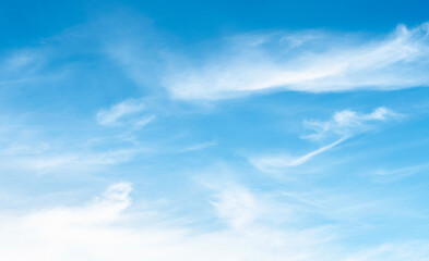 the sky is clear blue with fluffy white clouds, the sky is very bright, and the sun shines.