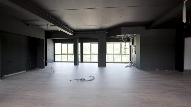 Slow dolly shot through a office space undergoing renovation with wires hanging