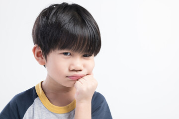 Close-up of a bored or thinking Thai boy resting his chin on his fist against a plain white background.