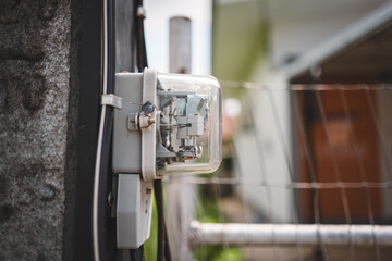 Electric meter attached to a post, showing details of the device and wiring.