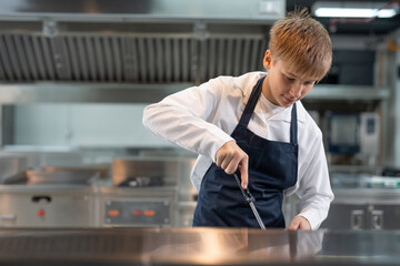 Student boy studying cooking food in class at school kitchen.
