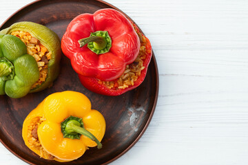 Baked stuffed pepper ( paprika ) with rice , carrot and meat . Top view on rustic background