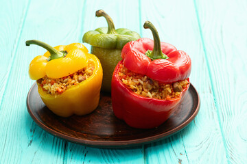 Baked stuffed pepper ( paprika ) with rice , carrot and meat . Top view on rustic background