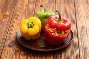 Baked stuffed pepper ( paprika ) with rice , carrot and meat . Top view on rustic background