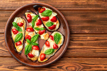 Italian mini pizza . Aubergine (eggplant ) with mozzarella cheese and basil . On rustic background