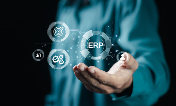 ERP, Enterprise resource planning concept, connections between business intelligence, HR and CRM modules. Businessman holding ERP icon on virtual screen.