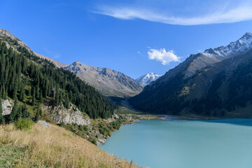 Beautiful mountain lake, forest and mountains. Big Almaty lake in summer time. Mountain landscape in Kazakhstan.