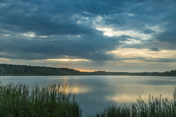 A lake with a cloudy sky in the background