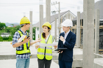 Contractor and architect looking at plan, tablet, laptop and talking about working on big project.