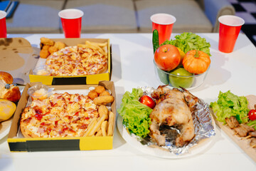 Mouth watering pizza, roasted chicken, fresh fruits, and drinks on a table. Perfect for food celebrations, gatherings,