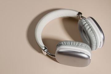 Gray headphones on a beige background. Wireless headphones