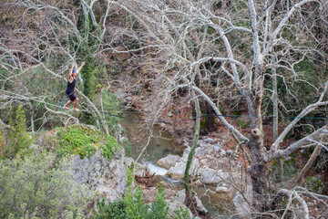 A tightrope walker walks along a cable stretched over a canyon.