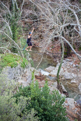 A tightrope walker walks along a cable stretched over a canyon.