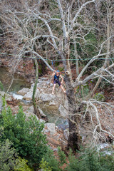 A tightrope walker walks along a cable stretched over a canyon.