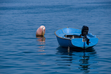 Kleines blaues Boot und eine Boje (nautic sea buoy) auf dem blauen Meer (Mittelmeer / Adria)