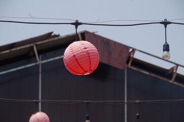 red lantern hanging lamp in daylight interior, hanging on long cable
