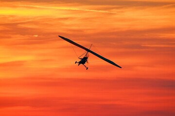 Ultralight Trike Flying Above Clouds at Sunset – Freedom and Adventure Concept