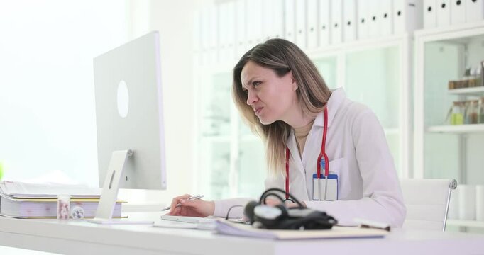 Emotional lady doctor reads patient tests result on computer at workplace. Therapist disappointed by wrong data in medical records in hospital