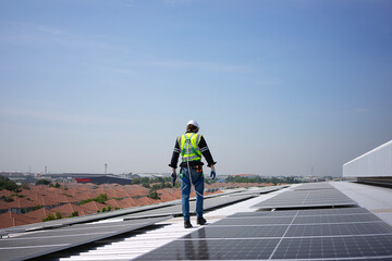 Blue collar worker is inspecting solar panel at rooftop of factory.