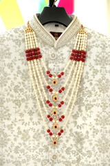 A close-up of intricate floral embroidery on a rich fabric, intricate embroidery and pearls. The detailed craftsmanship showcases traditional Indian design elements, adding elegance.