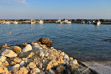 Small fishing boats in the harbor at sunset. Concept for travel and summer vacation. Greece-island of Corfu.