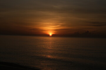 The sun rises at the sea in the morning.