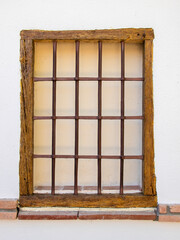 Ventana rústica con marco de madera y rejas de forja