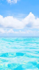 Tranquil blue ocean and fluffy white clouds on a sunny day.