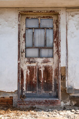 Old wooden door on the wall of an old house in the village