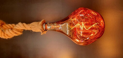 Decorative LED incandescent light bulb close-up. Modern rope chandelier. Vintage and retro lamp...